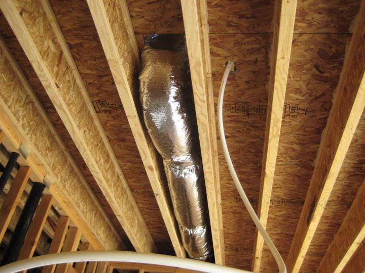 Moon Air technician servicing HVAC unit outdoors, tools and gauges attached