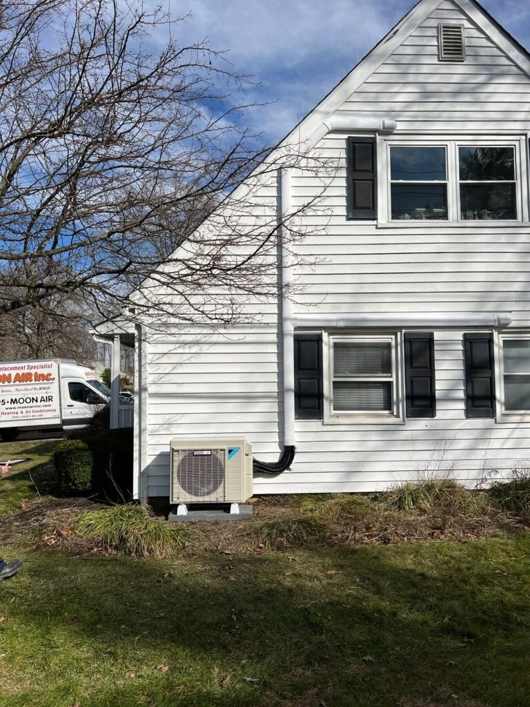 Moon Air technician servicing residential HVAC system, checking furnace components